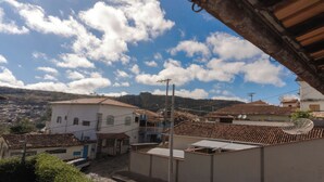 A residential area with terracotta-tiled roofs, a mix of single and multi-story buildings, and a hilly backdrop. - Comfort Suite 302 (Diamantina)