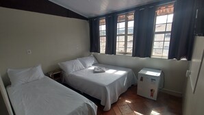A room with two beds, a window with curtains, a ceiling fan, and a refrigerator. - Comfort Suite 302 (Diamantina)