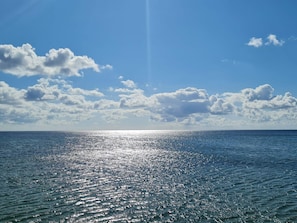 A calm sea with sunlight reflecting off the water, a clear sky, and scattered clouds. - 6 Person Holiday Home in Idestrup (Idestrup)