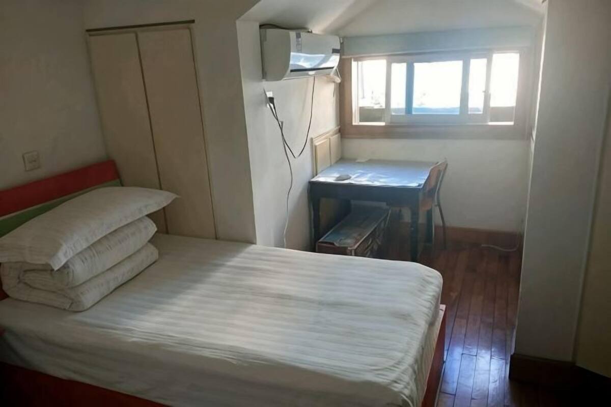 A room with a bed, a desk, and a window.