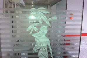 A room with a bed, a nightstand, and a wall with a decorative panel. - Xingwang Hostel (Shanghai)