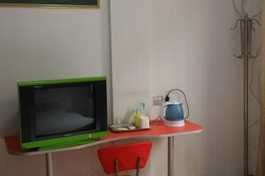 A small kitchenette with a microwave, a kettle, and a chair. - Xingwang Hostel (Shanghai)