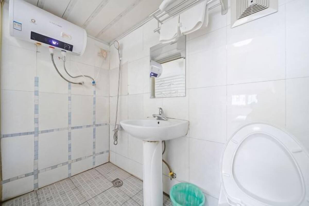 A bathroom with a white sink, toilet, and shower.