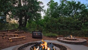 Un espace aménagé pour les feux de camp, avec des bancs et un panneau d’information.
