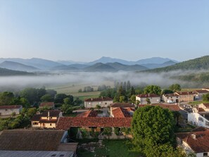 A village with traditional buildings, a valley, and mountains in the background. - La Ferme des Hautins (Rieucazé)