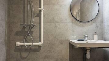 Un bagno moderno con doccia, lavabo e specchio.