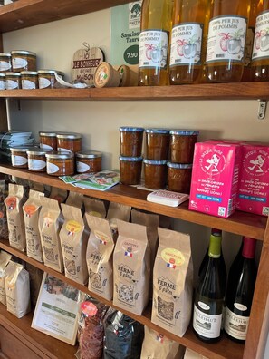 Shelves stocked with jars of preserves, bags of flour, and bottles of wine. - La Ferme des Hautins (Rieucazé)