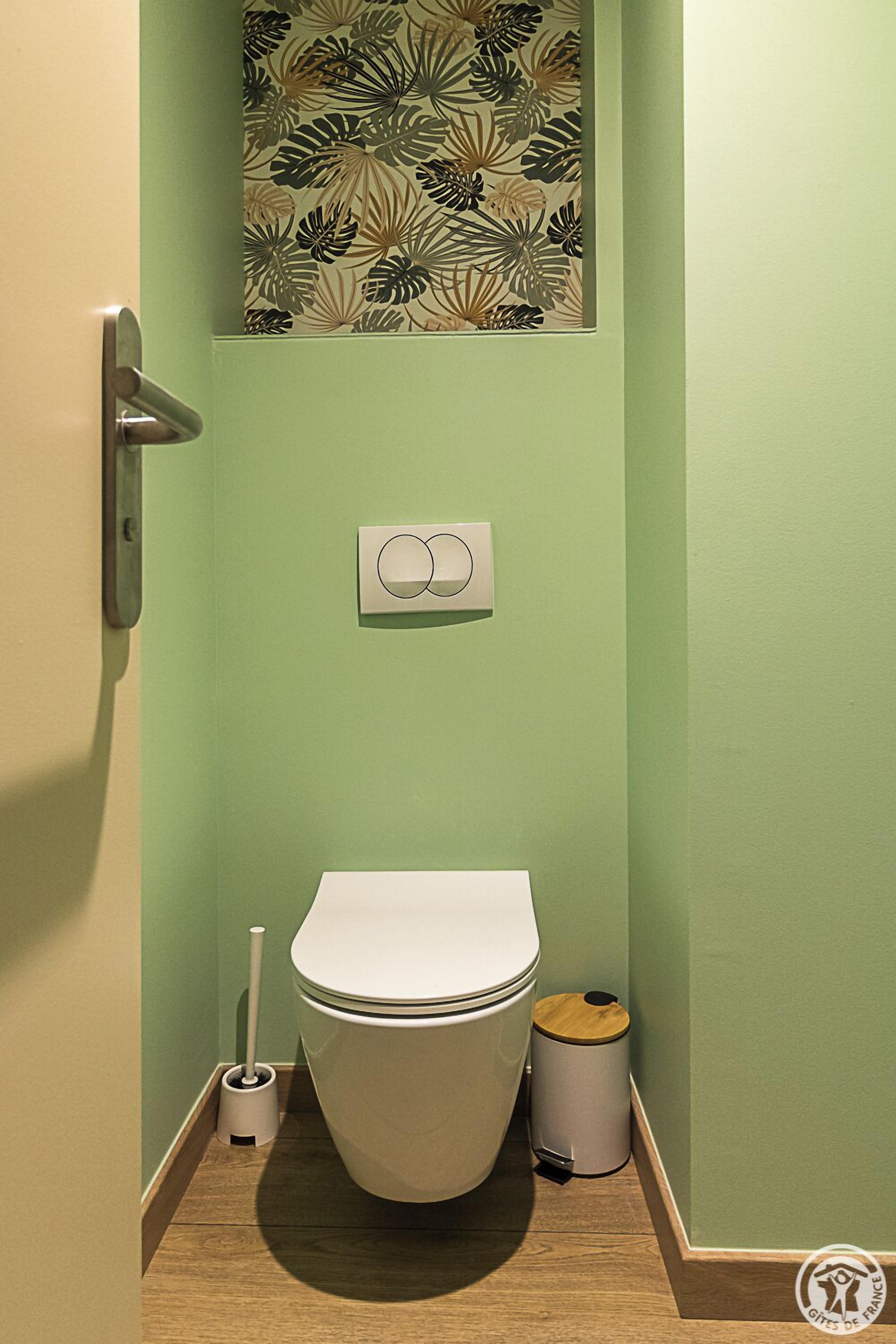 A bathroom with a toilet, a bidet, and a trash bin.