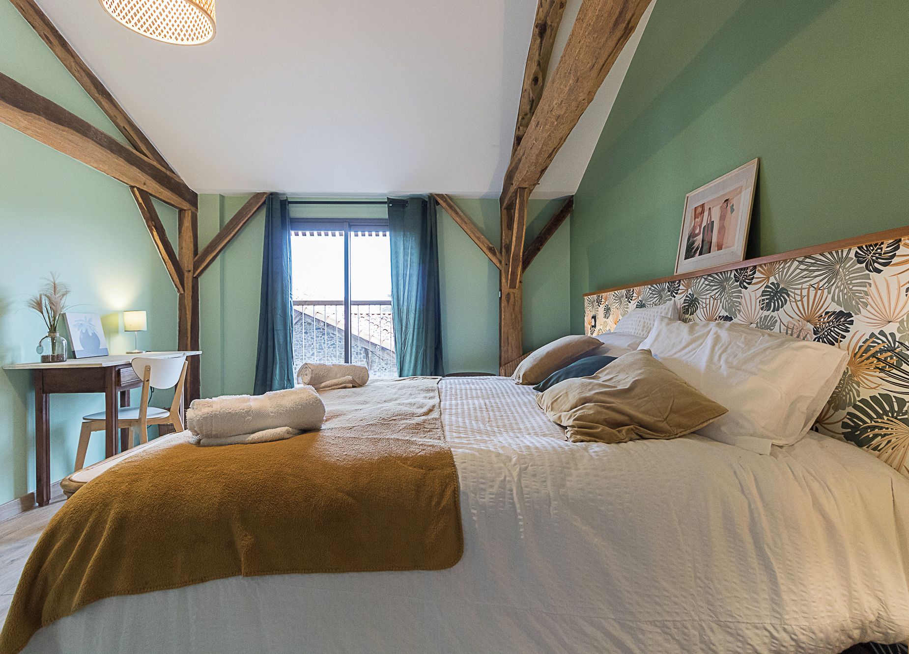 Un dormitorio con cama, escritorio y ventana.