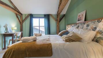 Um quarto com uma cama, uma escrivaninha e uma janela.