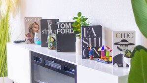 A white shelf with books, a small plant, and a decorative item. - Luxury 4BRS-3Baths Home, w/ King Bed & Private Gym (Katy)