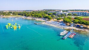 A coastal area with a marina, beach, and buildings. - Apartment in Liznjan Near Bora Beach (Liznjan)