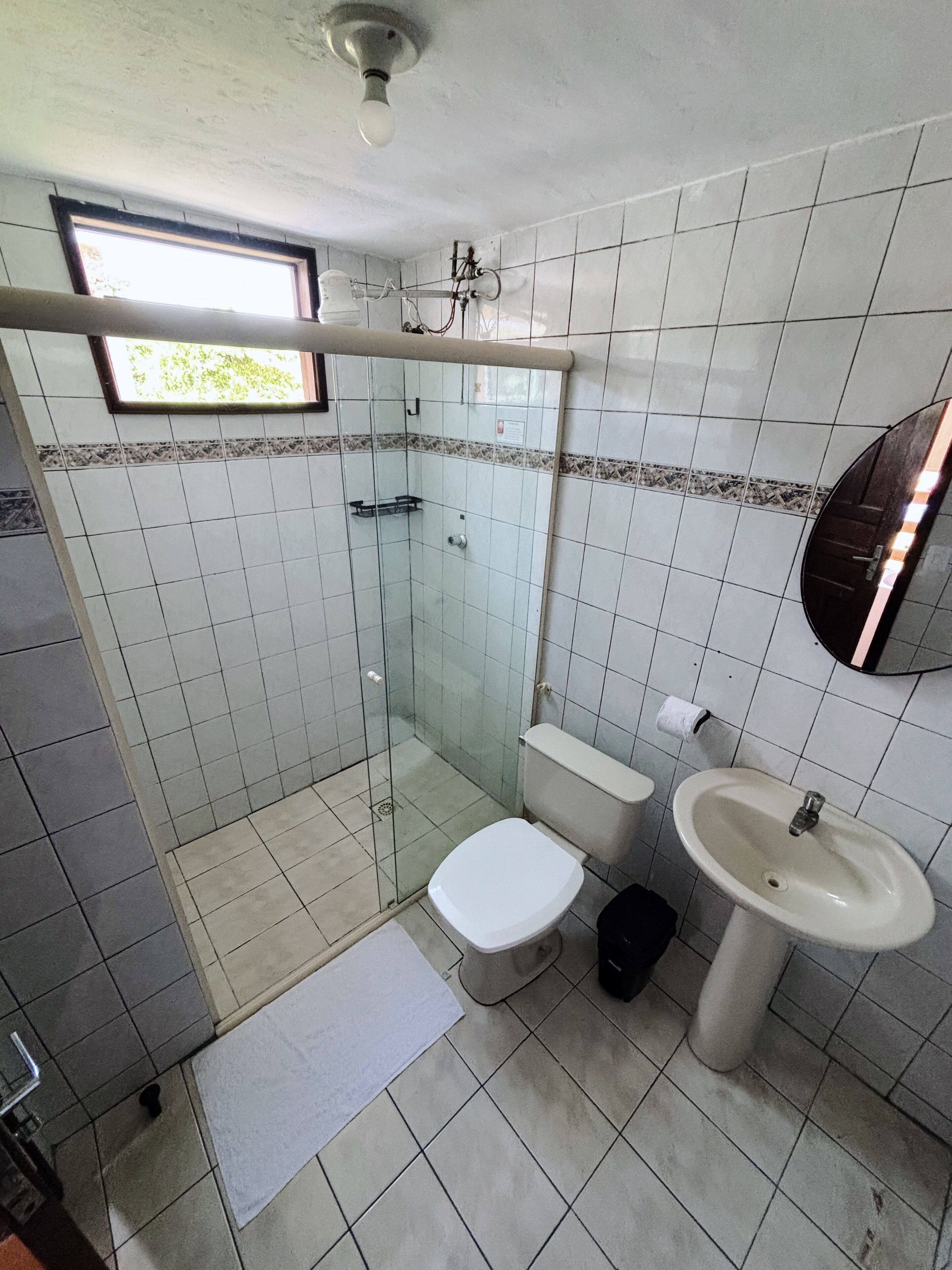 A bathroom with a toilet, sink, and glass-enclosed shower.