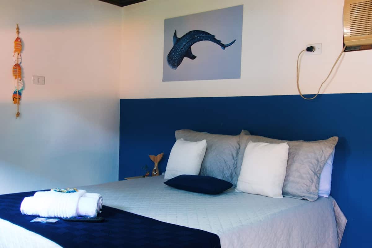 Un dormitorio con cama, candelabro, un cuadro en la pared y un calefactor de pared.