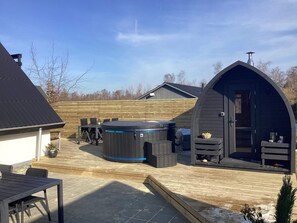 A hot tub, wooden deck, and a covered outdoor seating area. - 6 Person Holiday Home in Idestrup (Idestrup)