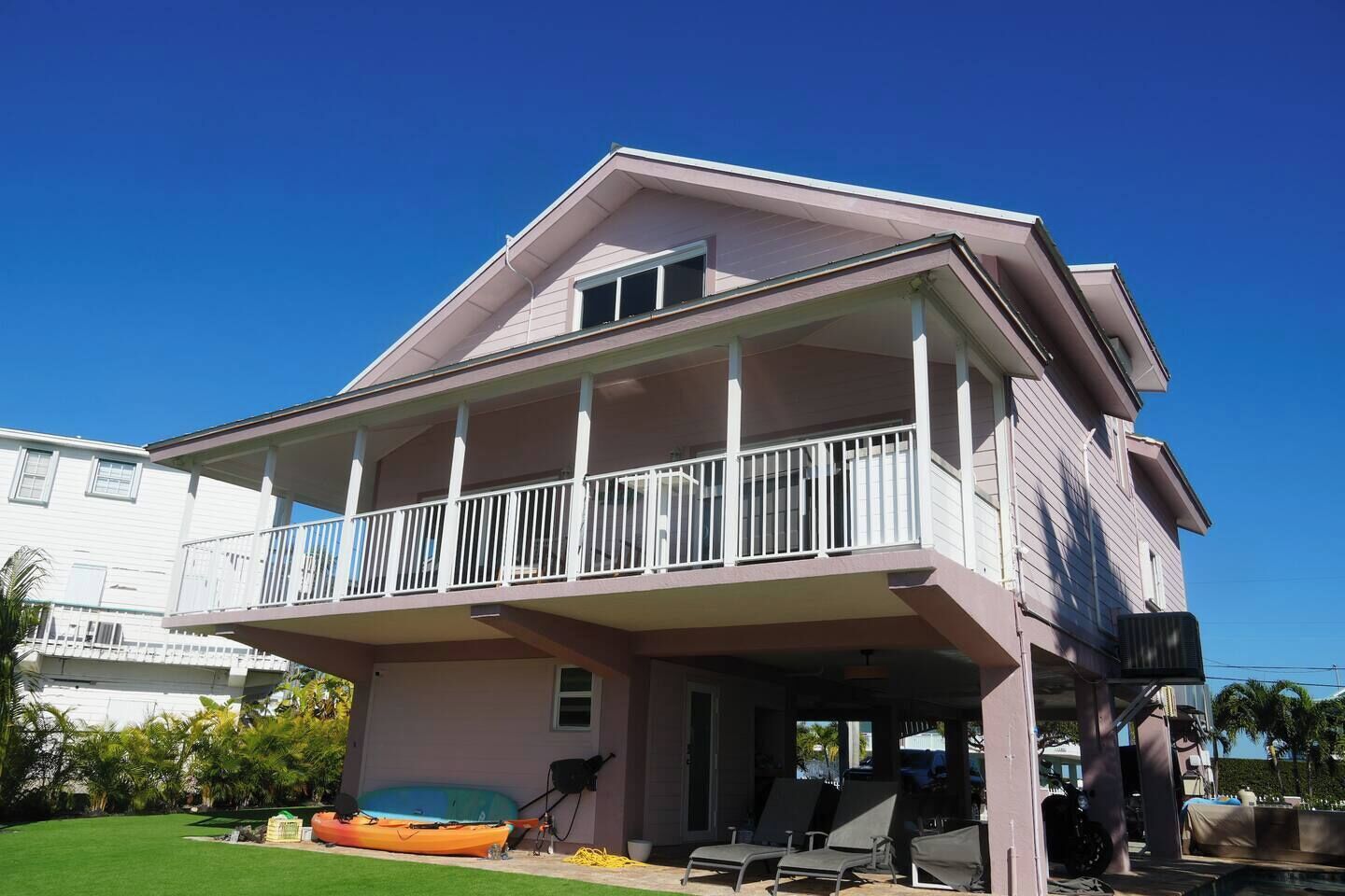 Une maison à deux étages dotée d’un balcon, d’un porche abrité et d’un petit espace piscine.