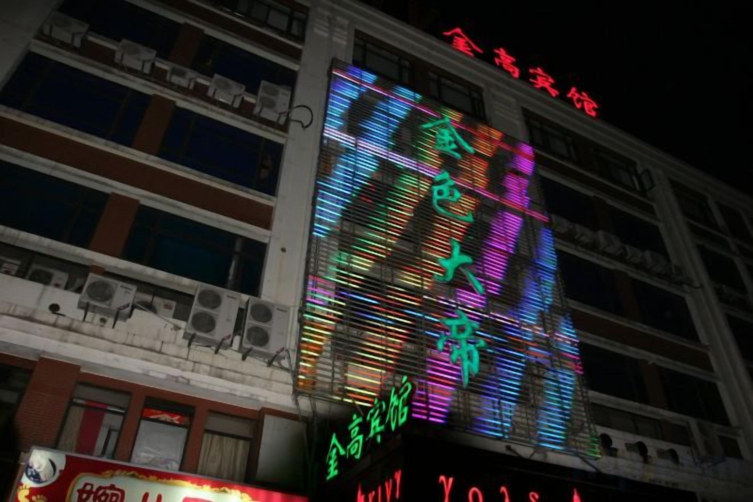 A multi-story building with illuminated signage and a large digital display.