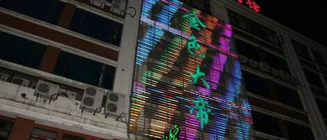 A multi-story building with illuminated signage and a large digital display.