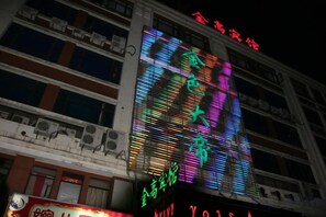 A multi-story building with illuminated signage and a large digital display. - Shanghai Golden Hotel (Shanghai)