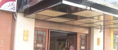 A storefront with a sign above the entrance, a door with glass panels, and a small awning.