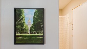 A framed photograph of a park with a prominent building and a statue, mounted on a white wall. - Rockne Quad<>Updated 3BR 2BA Home 1 Mi to ND (South Bend)