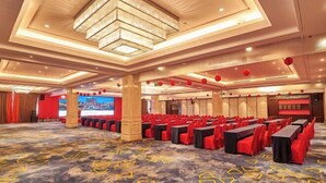 A conference room with rows of tables and chairs, a large screen, and a modern chandelier. - Fengda Hotel (Putian)
