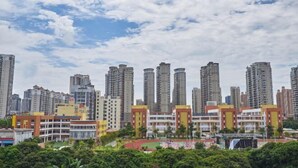 A high-rise residential building complex with multiple apartment buildings, a central courtyard with greenery, and a clear sky. - Fengda Hotel (Putian)
