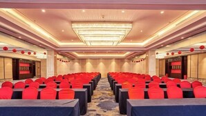 A conference room with rows of red chairs, a chandelier, and a carpeted floor. - Fengda Hotel (Putian)