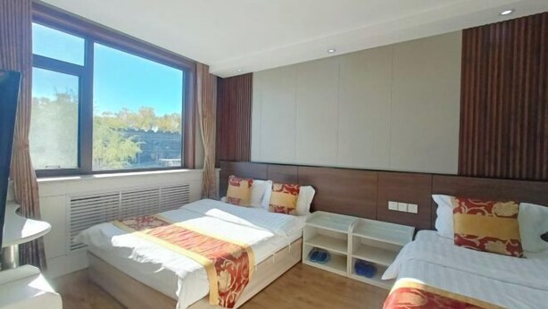 A hotel room with two beds, a large window, a TV, and a built-in shelf. - Qufu Ancient City Hotel (Sankong Scenic Area) (Qufu)