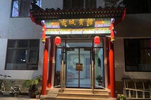 A traditional Chinese gate with illuminated signage, a tiled roof, and red pillars. - Qufu Ancient City Hotel (Sankong Scenic Area) (Qufu)