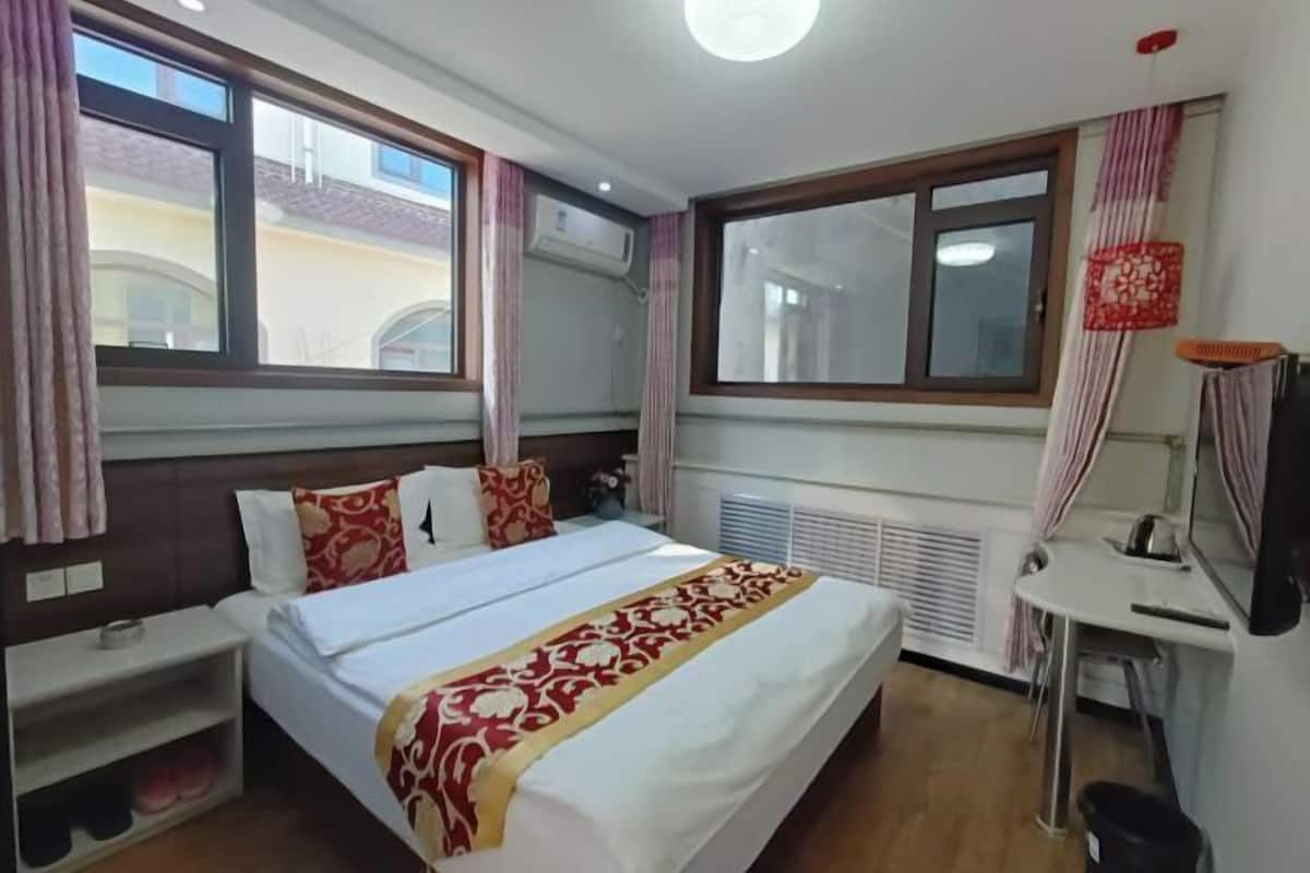 Une chambre d’hôtel avec un lit, une table de chevet et une fenêtre.