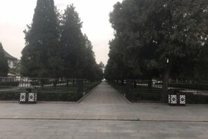 A paved pathway flanked by trees and fences, leading to a distant point. - Qufu Ancient City Hotel (Sankong Scenic Area) (Qufu)