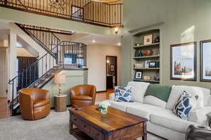 TV connectée, cheminée, livres, écrans d'ordinateur