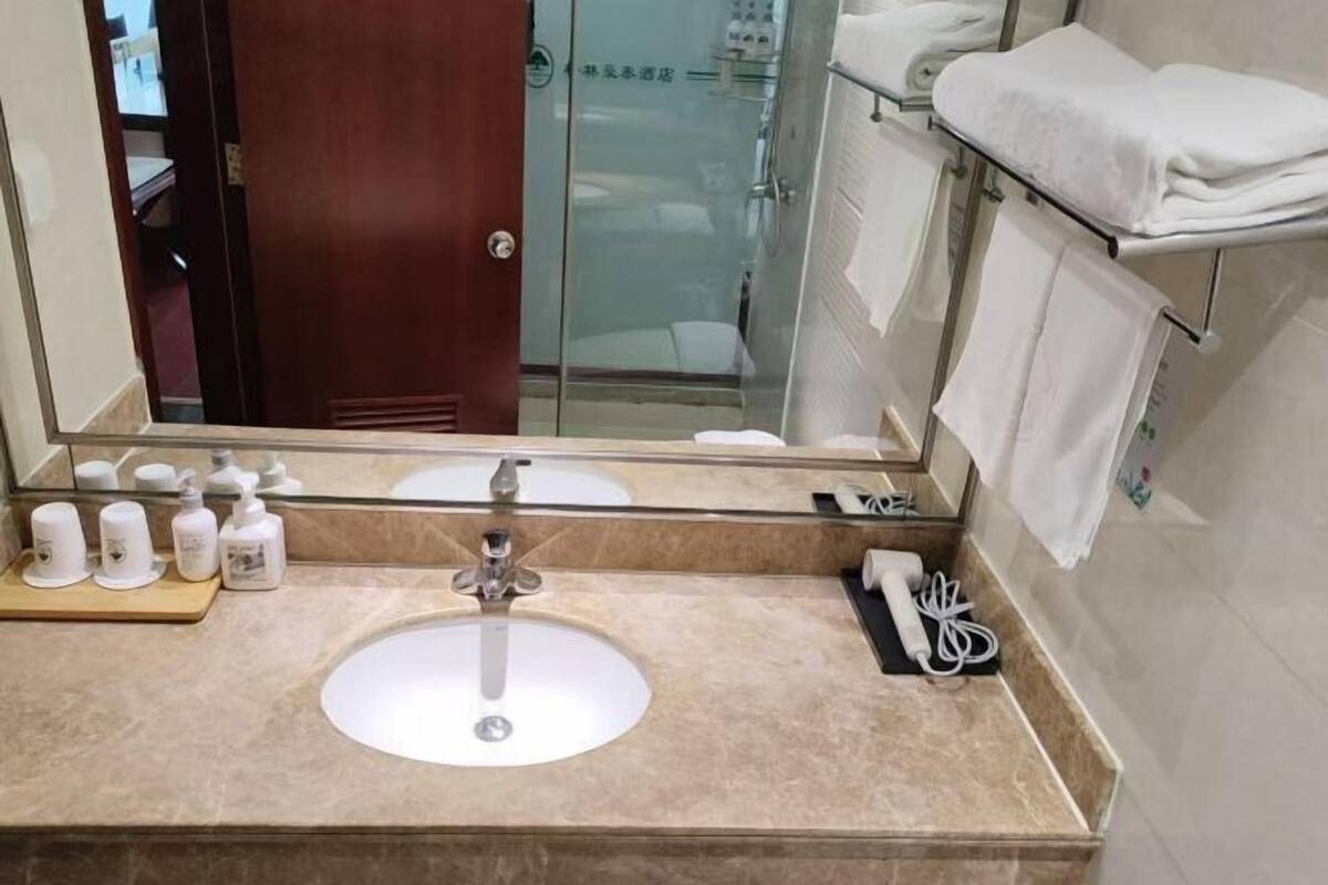 A bathroom with a sink, mirror, and towel rack.