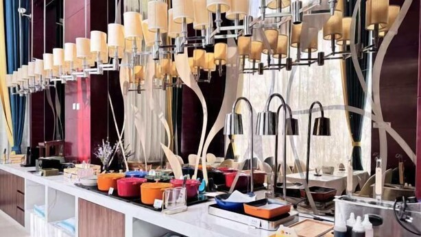 A modern kitchen with a long counter, various kitchen utensils, and a unique lighting fixture above the counter. - GreenTree Inn (Beijing Olympic Park National Tennis Center Hotel) (Beijing)