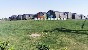 A row of modern buildings with flat roofs and large windows, situated on a grassy field. - GreenTree Inn (Beijing Olympic Park National Tennis Center Hotel) (Beijing)