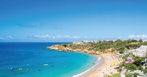 A coastal beach scene with clear skies, a sandy beach, and buildings along the coastline. - Ocean Drive by Check-in Portugal (Albufeira)