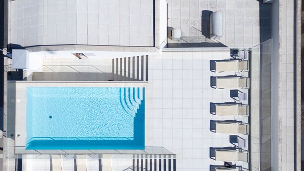 Eine Vogelperspektive eines Dachpools mit Sonnenterrasse und Liegestühlen.
