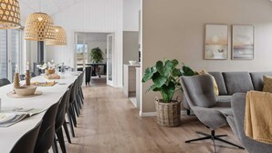 A spacious living area with a grey sofa, a large plant, and artwork on the wall. - 5 Star Holiday Home in Lokken (Lokken)