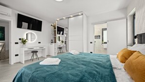 Une chambre à coucher moderne avec un lit, un bureau, un miroir et une armoire.