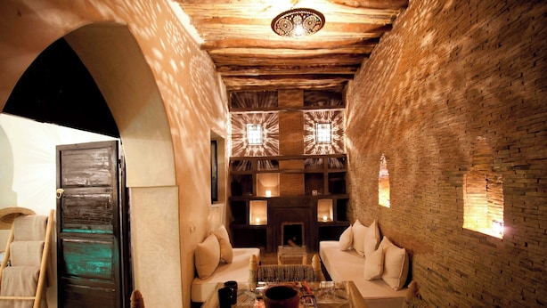 Un intérieur chaleureux avec une cheminée, un coin salon et un plafond en bois.