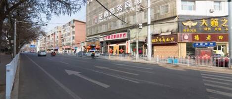 A street with storefronts, including a restaurant and a shop with a sign in a foreign language.