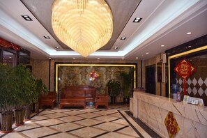 A lobby with a marble floor, a large wooden reception desk, and a hanging light fixture. - Lanzhou Huayu Business Hotel (Lanzhou)