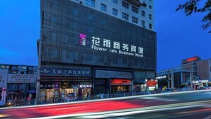 Un hotel con un cartel grande que dice 'Flower rain Business Hotel'.