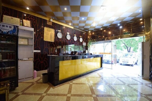 A hotel reception area with a check-in counter, a vending machine, and a tiled floor. - Affirm Crystal Hotel (Jiangning Wanda Shangyuan Street) (Nanjing)