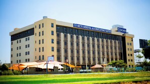 Un gran edificio de hotel con varios pisos, que muestra un letrero para RCTI Hostel & Executive Suites.