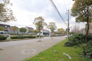 A street with a bus, trees, and buildings. - Shanghai Xiangyuan Hotel (Shanghai)