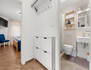 A modern bathroom with a sink, toilet, and shower area.