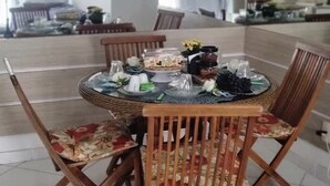 Un comedor con una mesa redonda, sillas y una lámpara colgante.