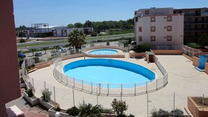 A rooftop swimming pool with a clear view of the surrounding buildings and road. - Studio cabin terrace swimming pool parking (LE GRAU DU ROI)